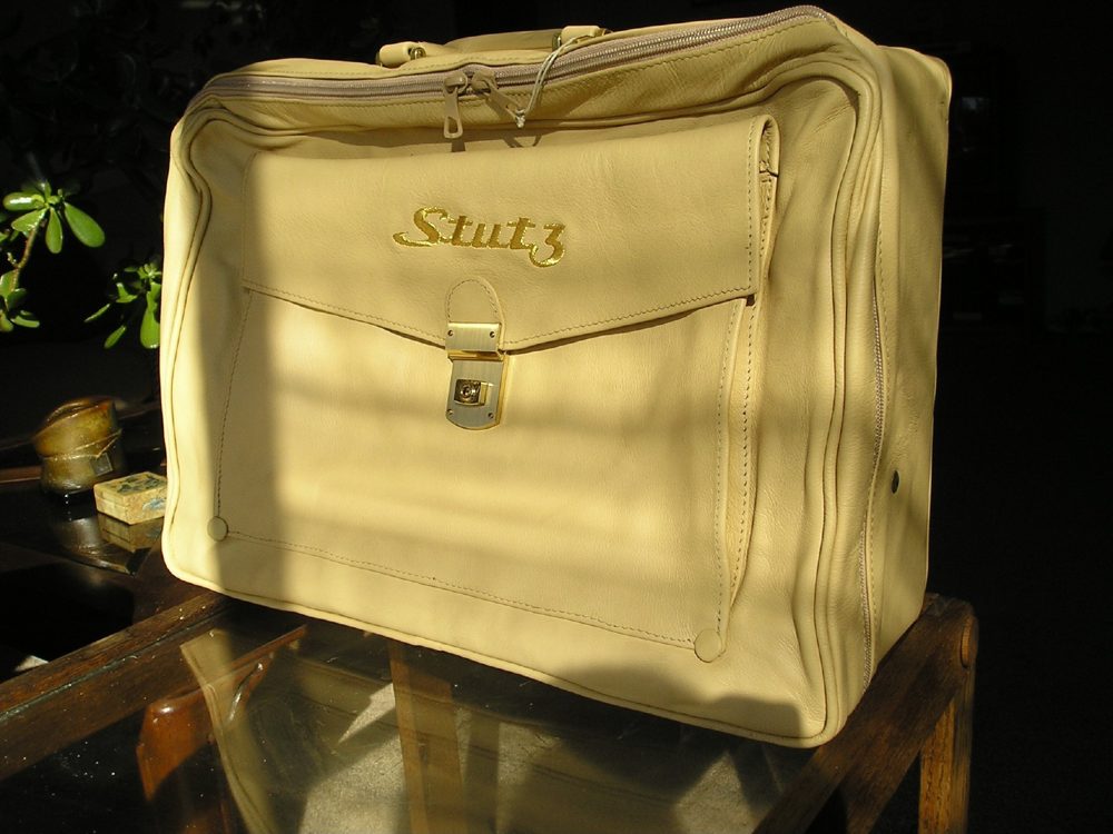 Stutz leather valise in champagne calfskin with brass hardware and the gold Stutz script on the front pocket