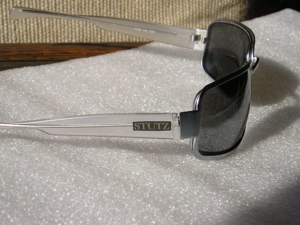 Stutz sunglasses — polished chrome frame with smoked lenses, STUTZ engraved on the temple